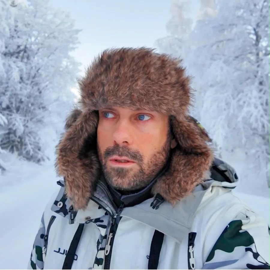 Guide in a traditional fur trapper hat in the snowy taiga